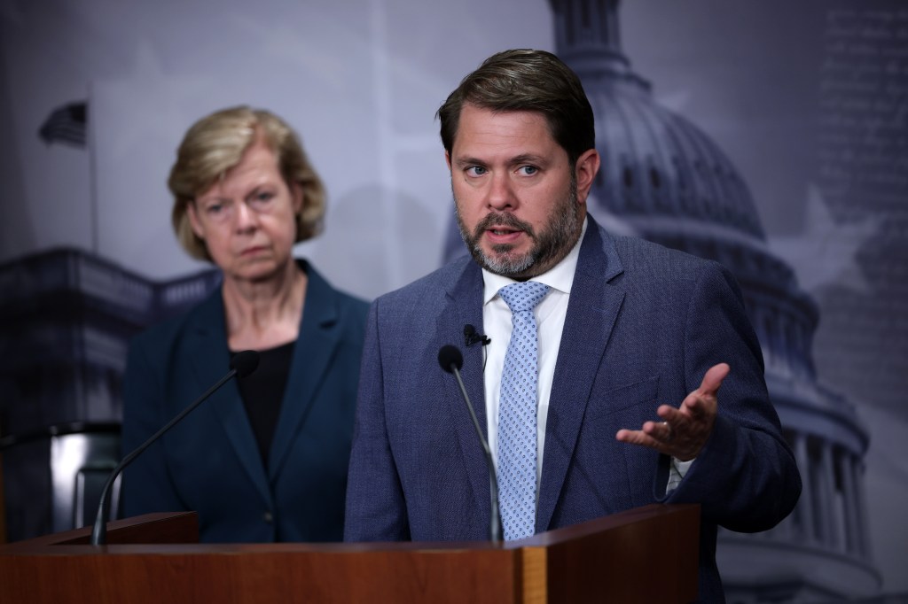 Sen. Ruben Gallego speaking at a news conference with Sen. Tammy Baldwin listening in the background.