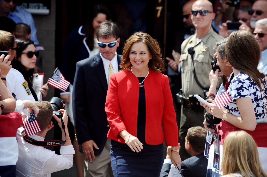 Darline Graham Nordone, sister of Sen. Lindsey Graham, walking towards the stage at a political event.