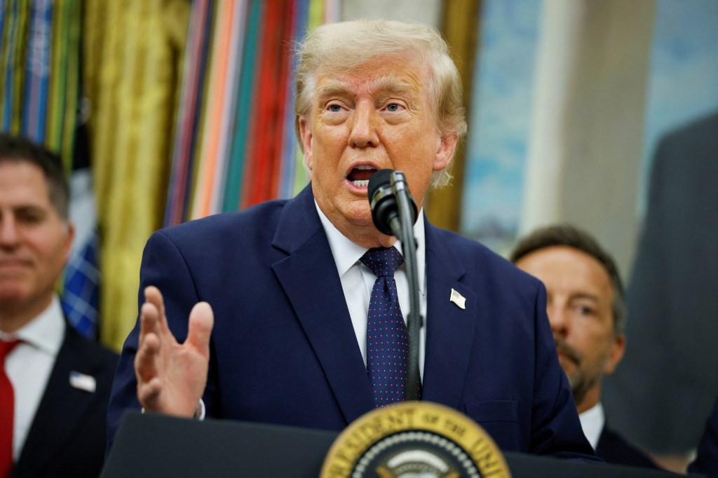 President Donald Trump speaks at a podium in the White House Oval Office.