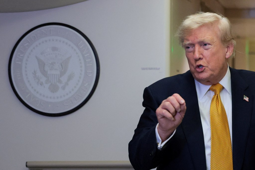 President Donald Trump speaks to reporters in the press cabin of Air Force One.